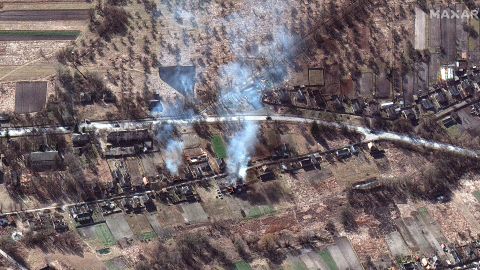 The Russian convoy is seen alongside smoke rising from what appears to be burning homes, northwest of Invankiv, Ukraine.
