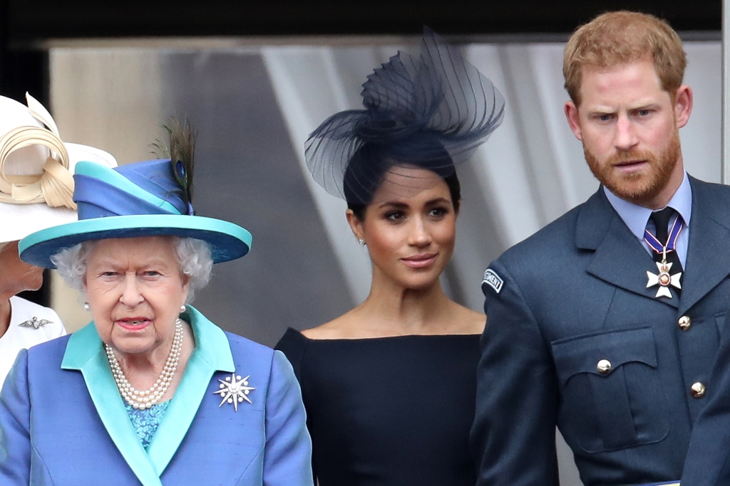 Queen Elizabeth II, Prince Harry, Duke of Sussex and Meghan, Duchess of Sussex on the balcony of Buckingham Palace as the royal family attends events to celebrate the centenary of the RAF on July 10, 2018 in London, England. 