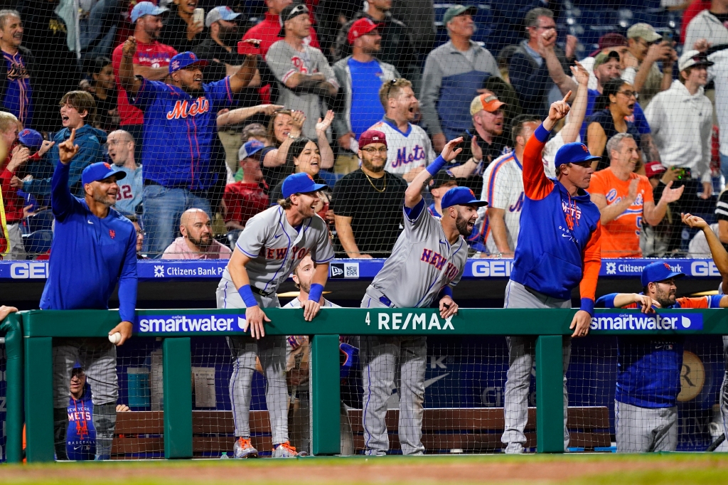 The Mets celebrate in the dugout during their ninth inning rally.
