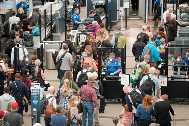 Passengers line up through the northern security checkpoint at the main terminal of Denver International Airport, Thursday, May 26, 2022, in Denver.