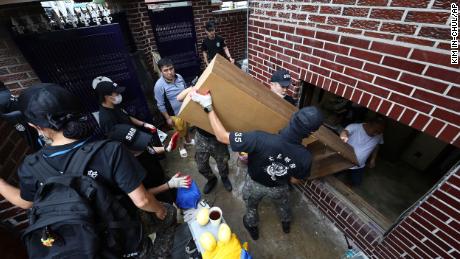 Soldiers carry debris from a flooded house in Seoul, South Korea, on August 10.
