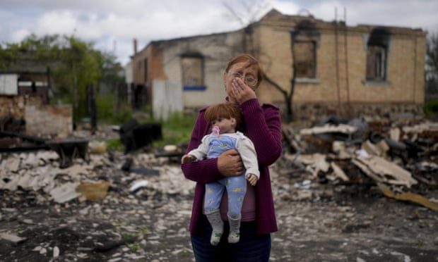 Nella Zelenska holds a doll belonging to her granddaughter in front of her destroyed home in Potashnya, outside Kyiv, Ukraine, in May.