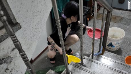 A woman shovels water from a flooded basement apartment in Seoul, South Korea, on August 10.
