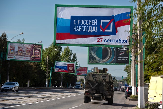 Military vehicle running along the street with a billboard "With Russia forever, September 27" Before the referendum in Luhansk, Luhansk People's Republic controlled by Russia-backed separatists, eastern Ukraine, Thursday, September 22, 2022.
