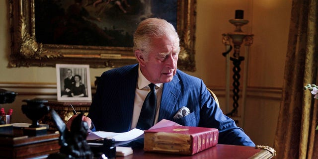 In this September 11, 2022 photo, Britain's King Charles III carries out official government duties from his red chest in the 18th century room at Buckingham Palace, London.  (Victoria Jones/PA via AP)