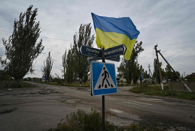 A Ukrainian flag waves on a street in the recently liberated village of Vysokopila, Kherson region, on September 27, 2022.