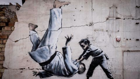 A mural that Banksy has not officially claimed shows a man turning over during a judo match with a boy. 