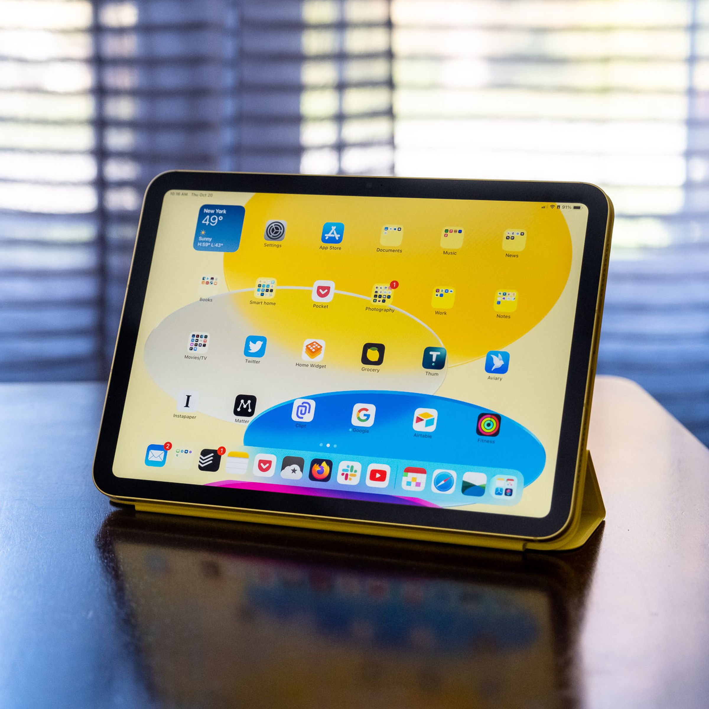 A 10th generation iPad in an Apple Smart Folio on a wooden table.