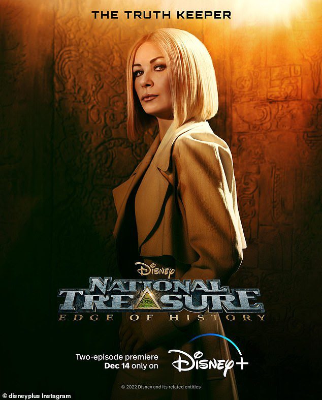 Change up: Zeta-Jones trades in Morticia's trademark black hair for a blonde bob and sleek khakis in National Treasure: Edge of History, out Dec. 14 on Disney+